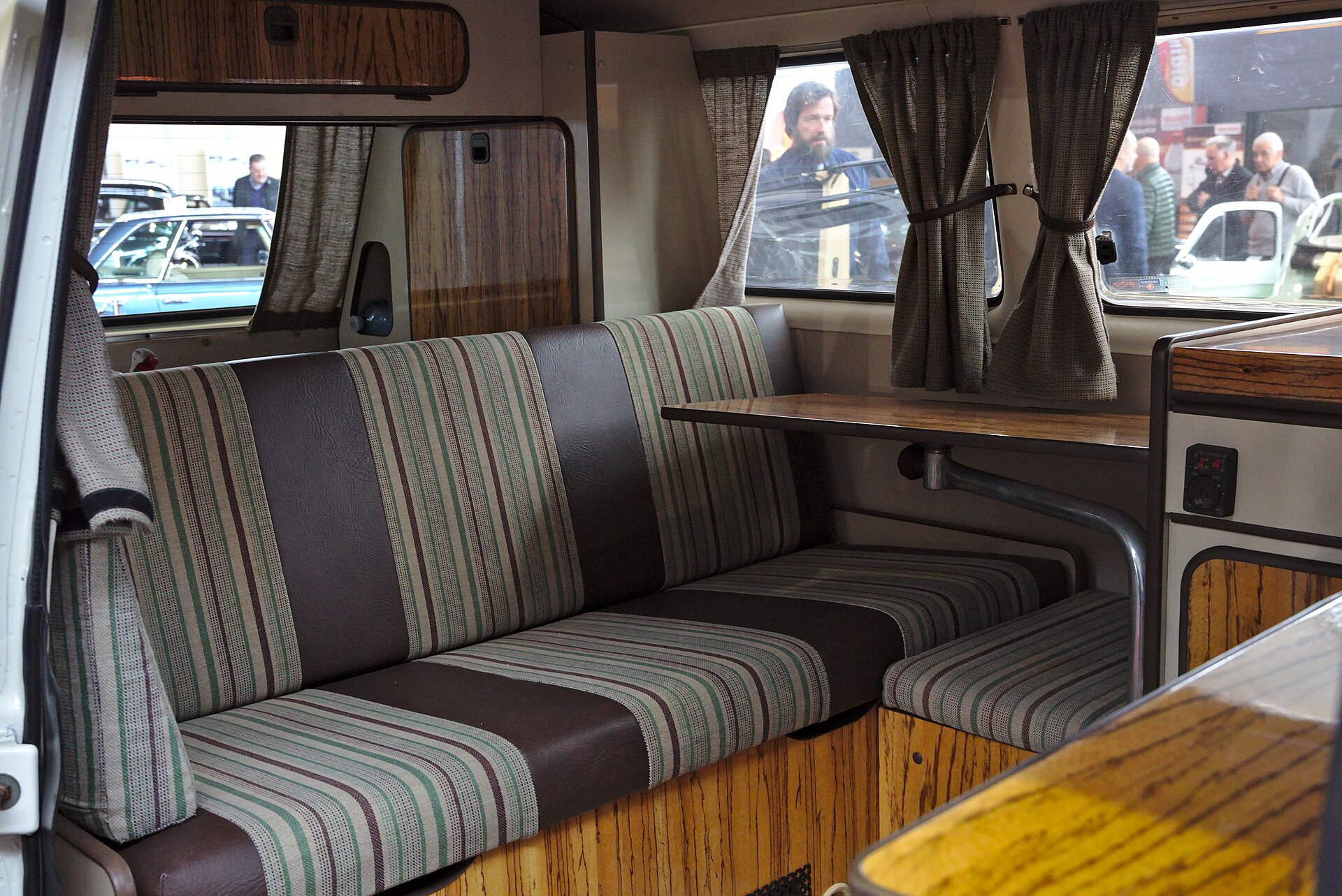 The inside of a Volkswagen Westfalia with orange curtains
