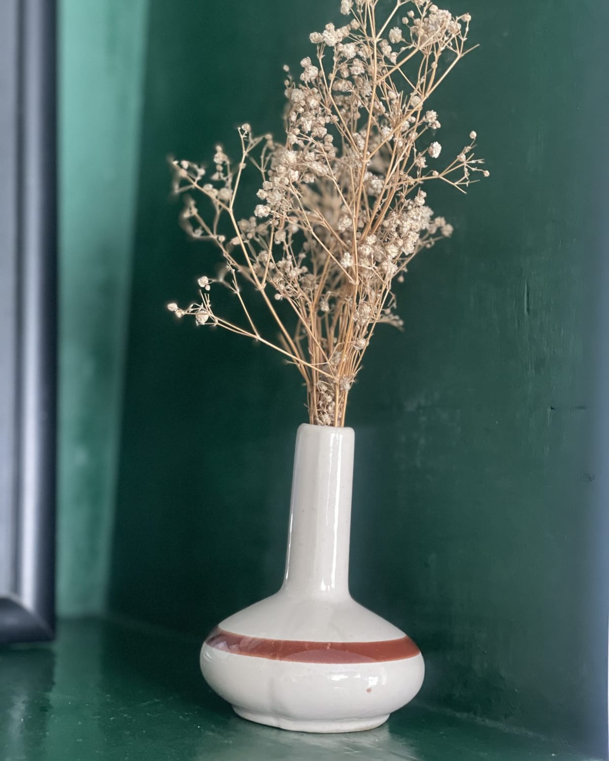 Dried grasses in a banded stoneware vase.